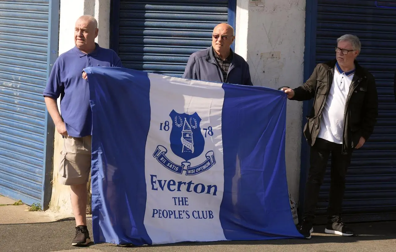 Everton fans hold up a flag as they pay tribute to Kevin Campbell