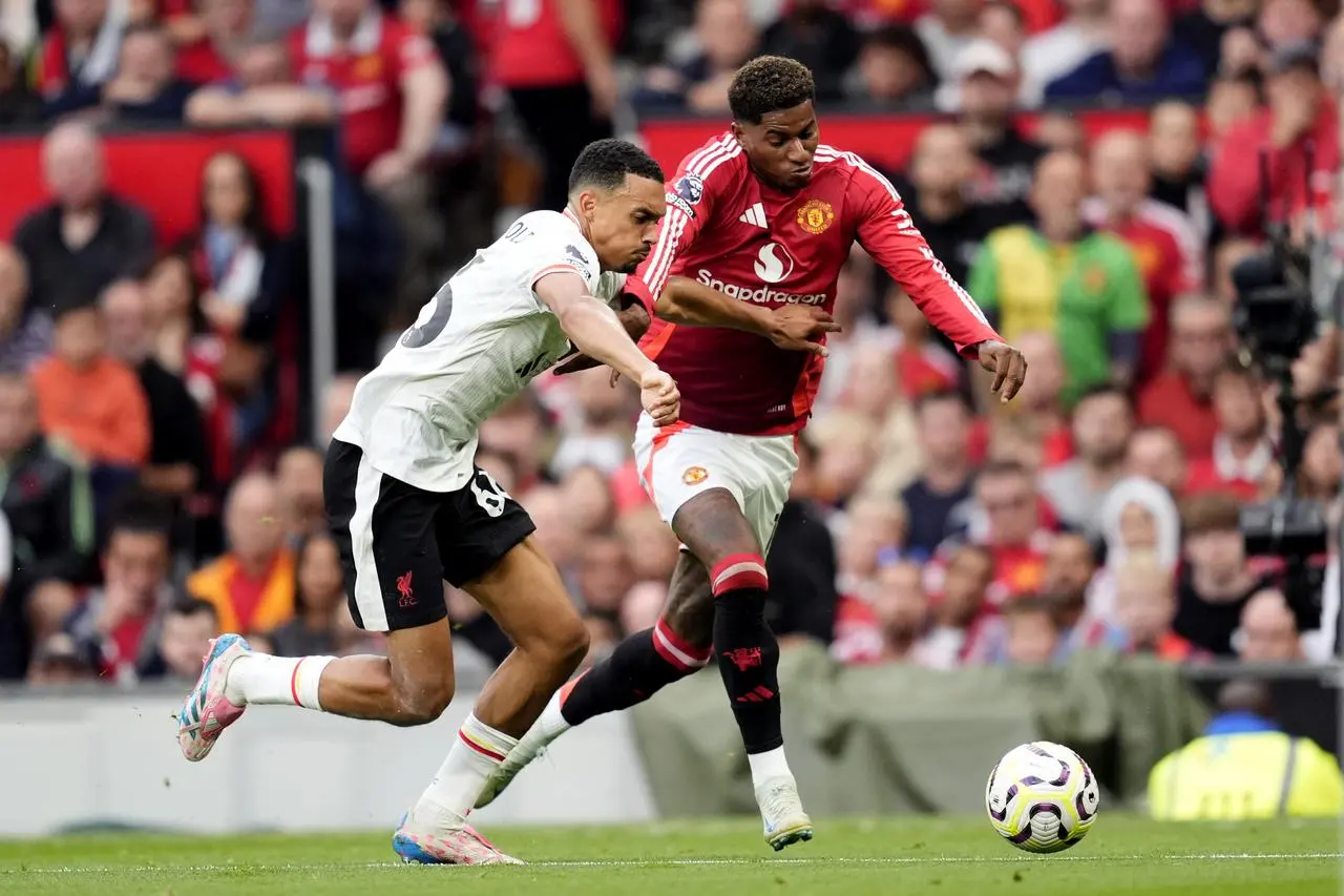 Liverpool's Trent Alexander-Arnold attempts to tackle Manchester United’s Marcus Rashford