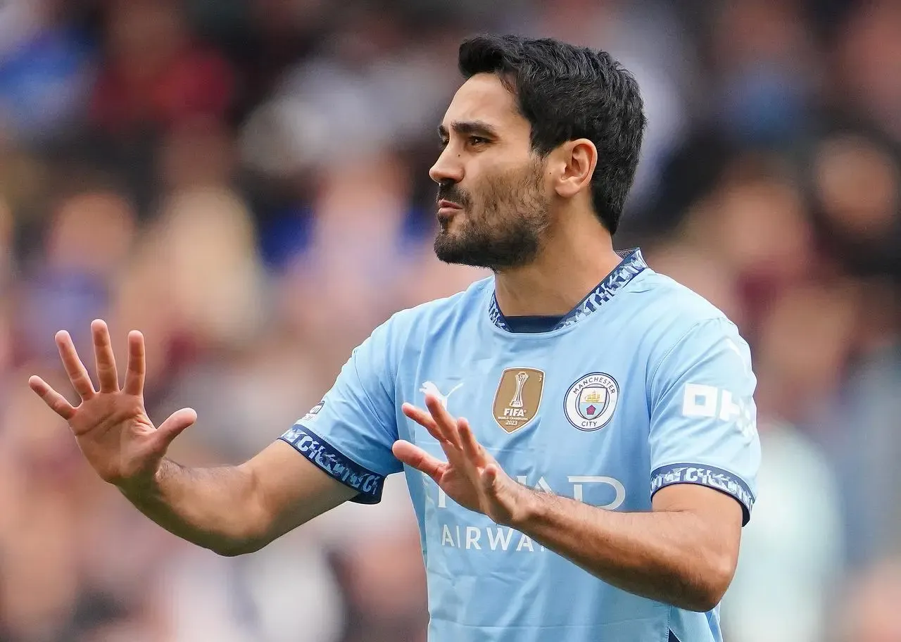 Manchester City midfielder Ilkay Gundogan raises both palms in front of him