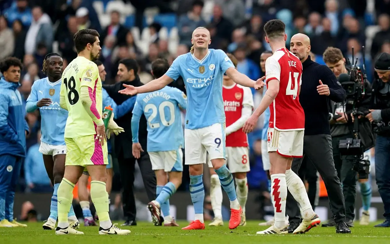 Erling Haaland puts his arms out as Pep Guardiola speaks to Declan Rice