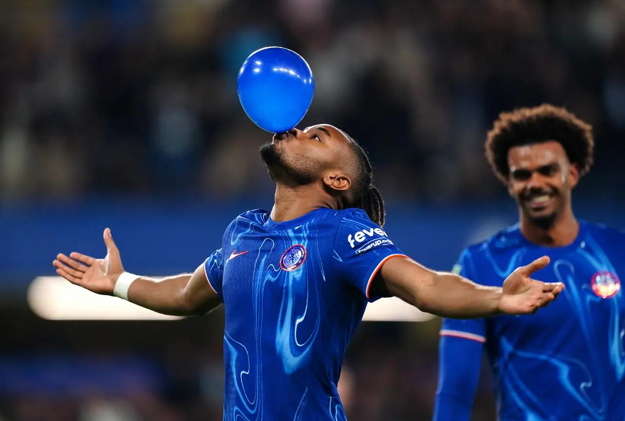 Christopher Nkunku blows up a balloon to celebrate scoring a hat-trick in Chelsea's win over Barrow