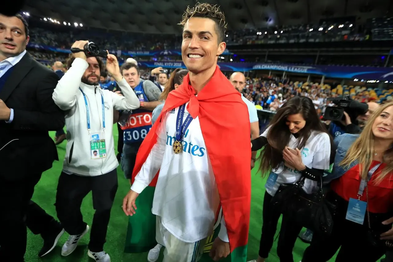 Cristiano Ronaldo, draped in a Portugal flag, celebrates Real Madrid's 2018 Champions League win against Liverpool in Kyiv