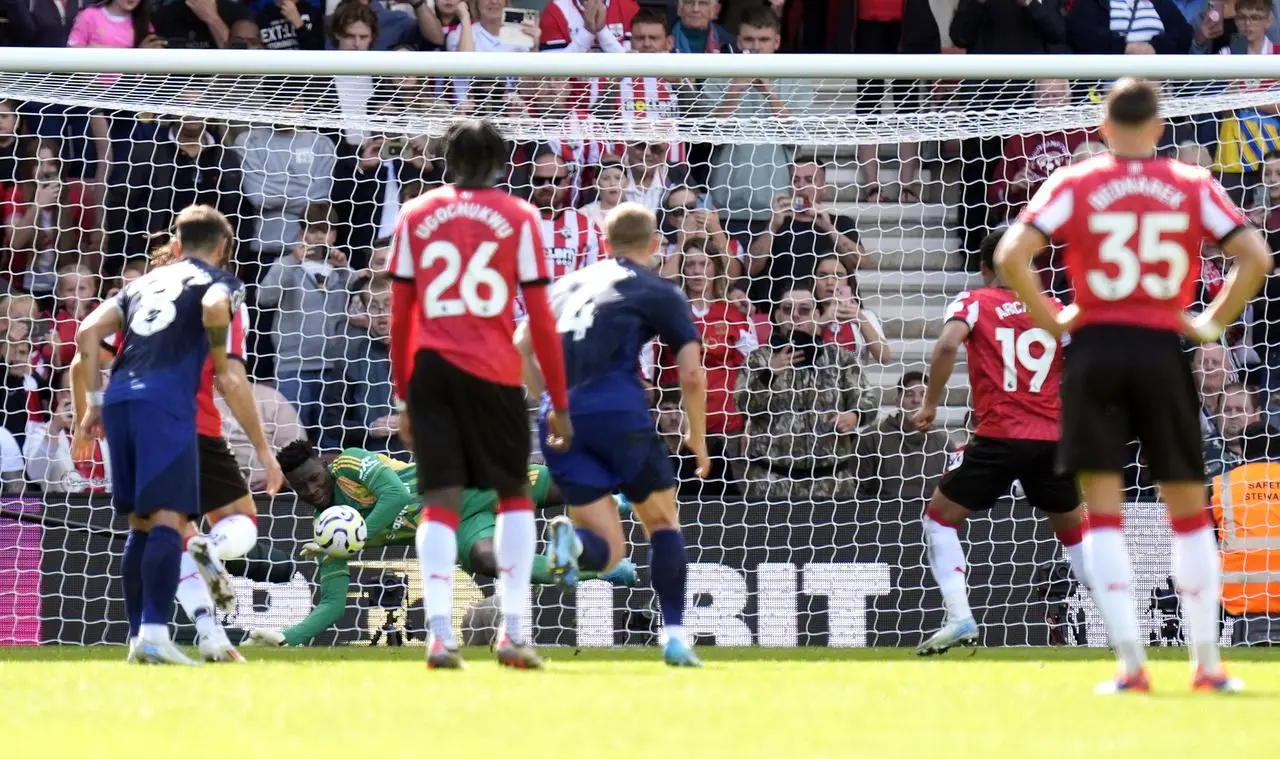 Manchester United goalkeeper Andre Onana saves Southampton striker Cameron Archer's spot-kick, diving to his right