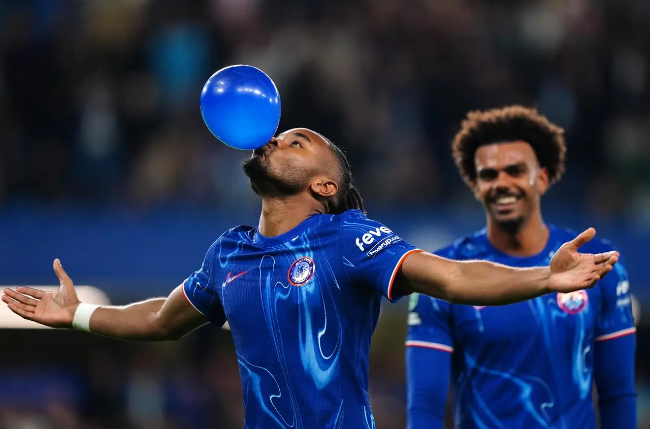 Chelsea's Christopher Nkunku, left, blows up a blue balloon to celebrate his Carabao Cup hat-trick against Barrow