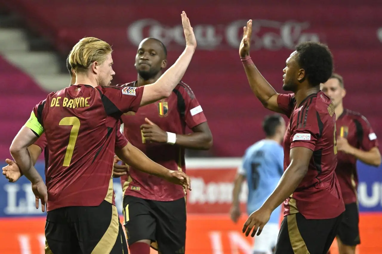 Belgium's Kevin De Bruyne, left, high-fives Lois Openda after scoring against Hungary