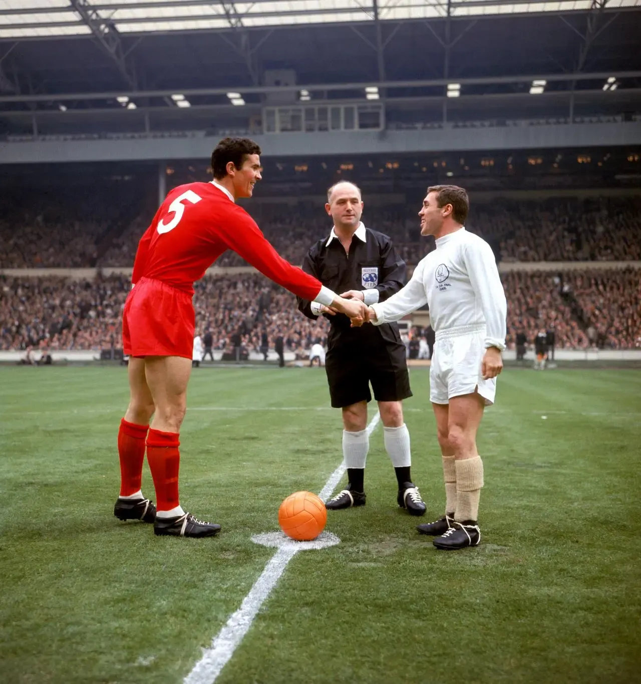 Liverpool's Ron Yeats in red (left) shakes hands with Leeds captain Bobby Collins in white in front of the referee at the 1965 FA Cup final at Wembley. 