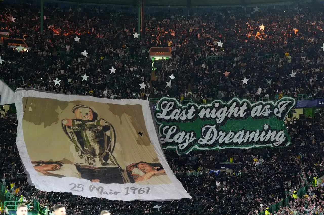 Celtic fans with a banner of the European Cup and a sign which says 'Last night as I lay dreaming'