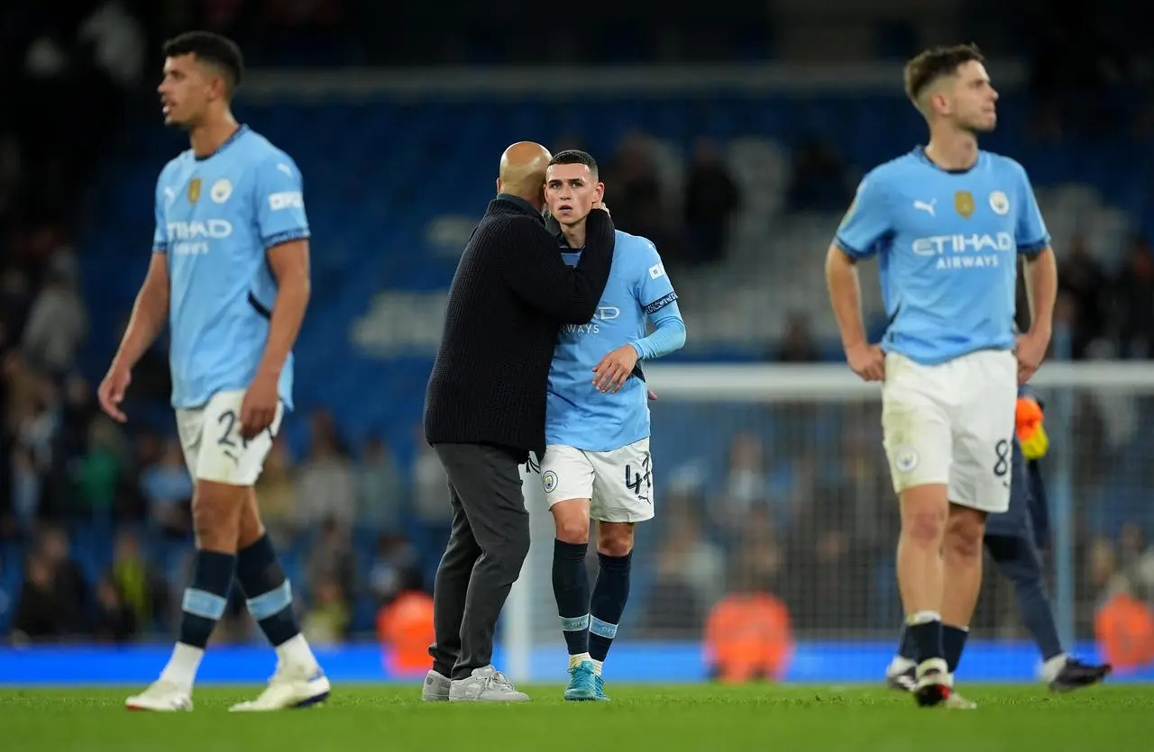 Pep Guardiola, centre left, speaks to Phil Foden as they, Matheus Nunes, left, and James McAtee, right, leave the pitch after Manchester City's win over Watford