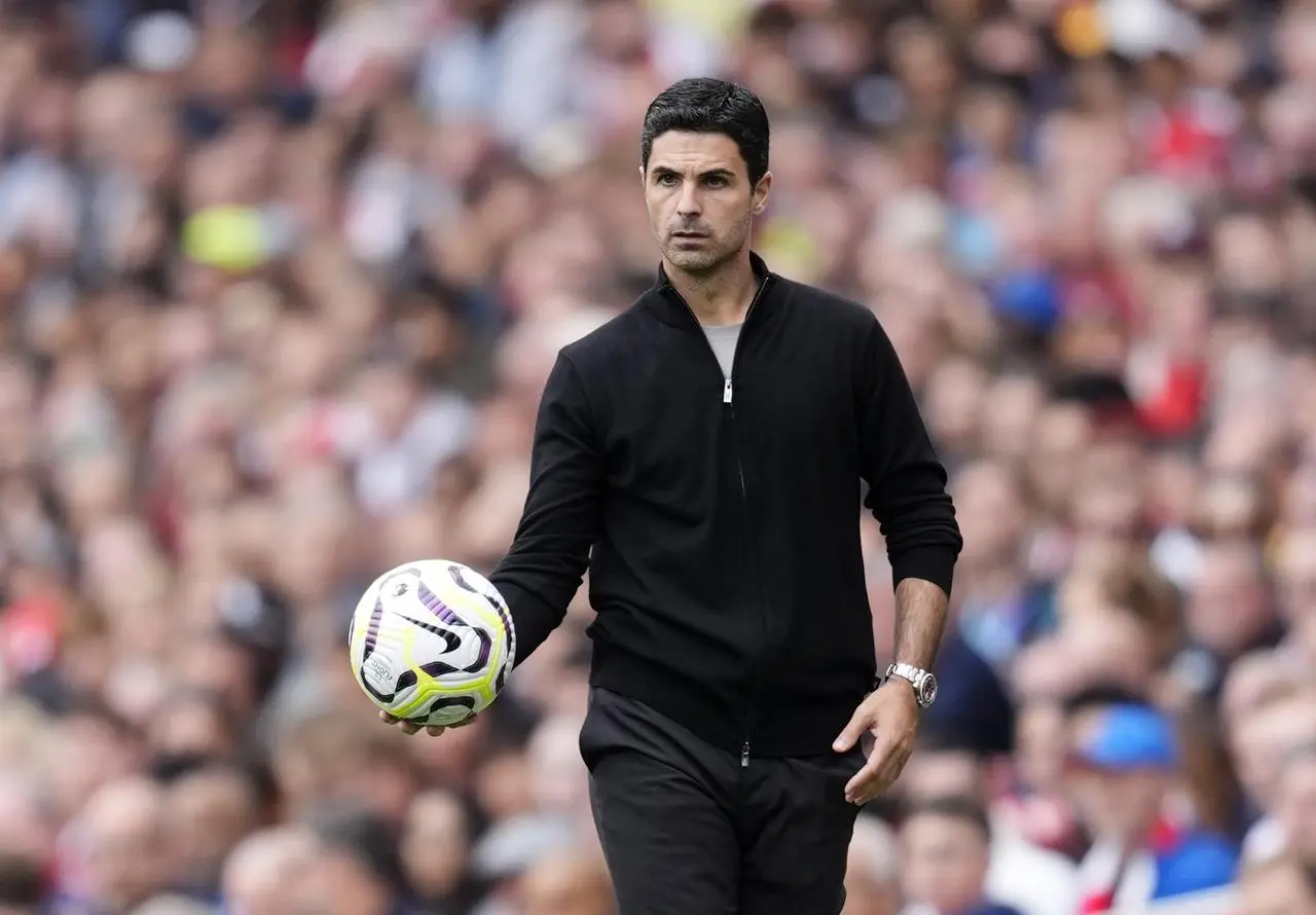 Mikel Arteta holds a ball on the touchline