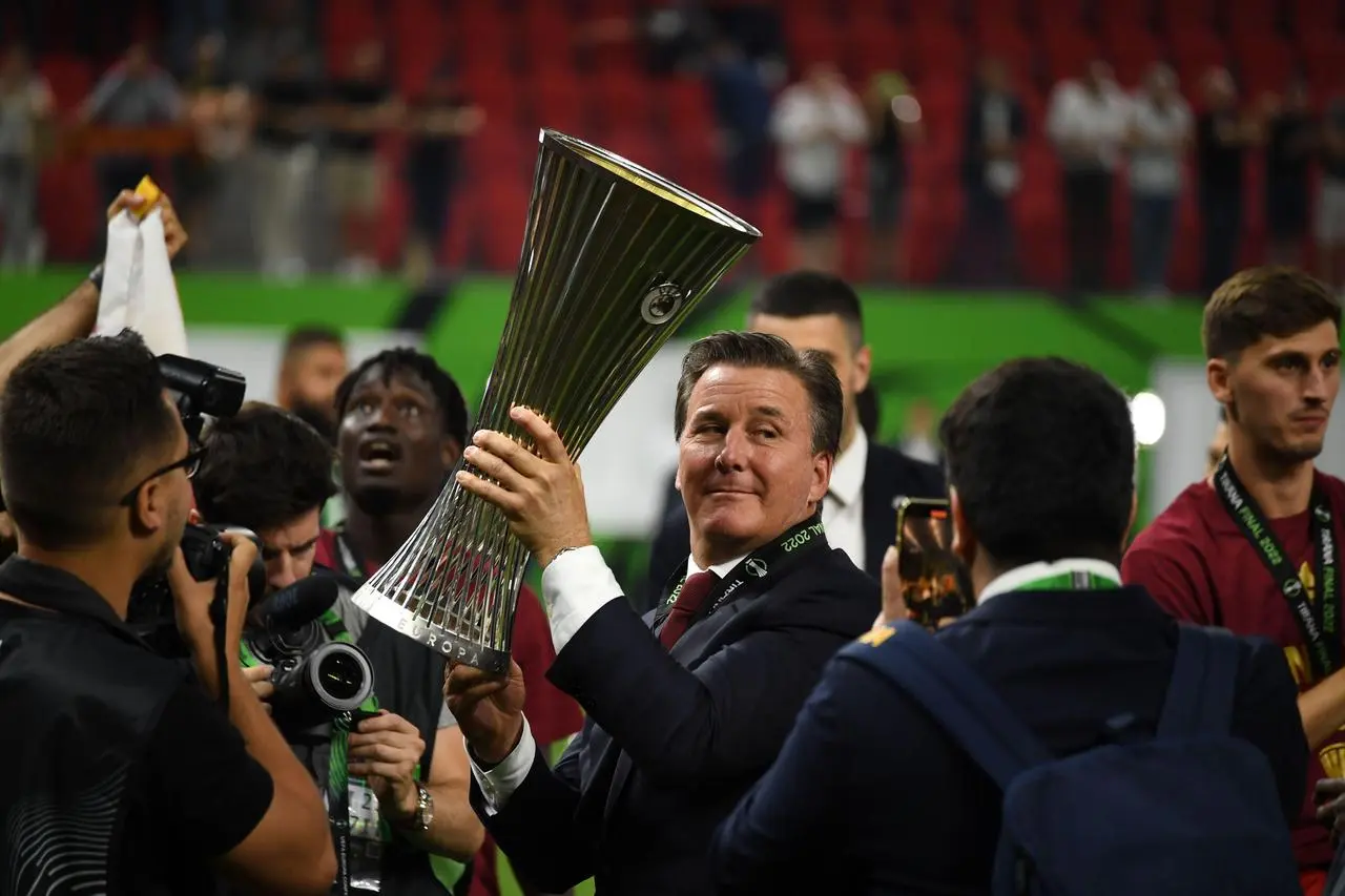 Roma owner Dan Friedkin lifts the UEFA Conference League trophy