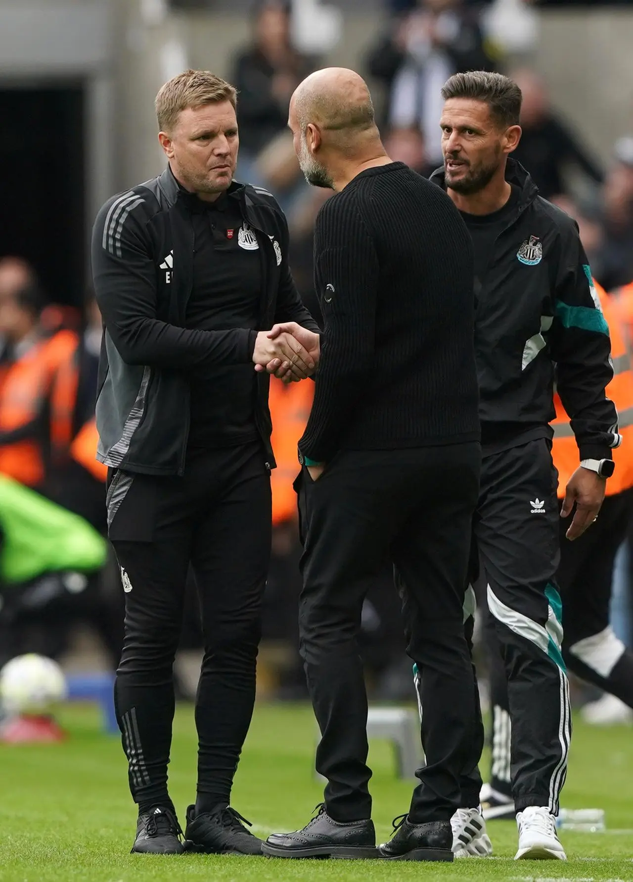 Newcastle United manager Eddie Howe (left) and Manchester City manager Pep Guardiola shake hands as Jason Tindall looks on