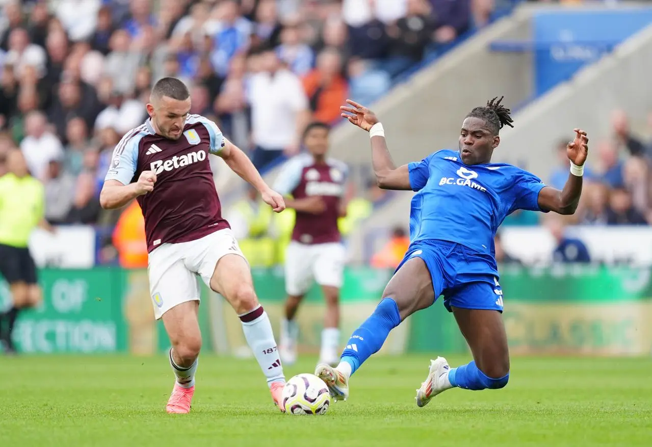 Leicester's Caleb Okoli slides in to tackle Aston Villa's John McGinn