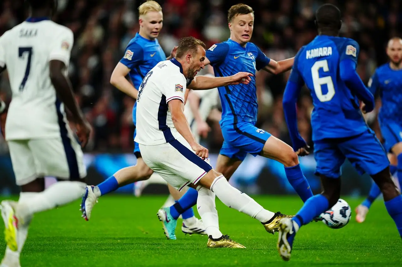 England’s Harry Kane, wearing gold boots and surrounded by Finland defenders, scores the first of his two goals