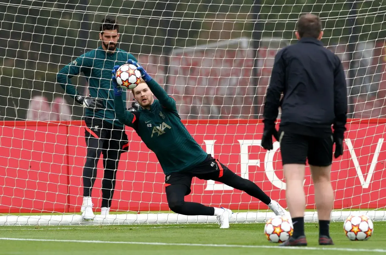 Liverpool goalkeeper Caoimhin Kelleher makes a save in training as Alisson looks on