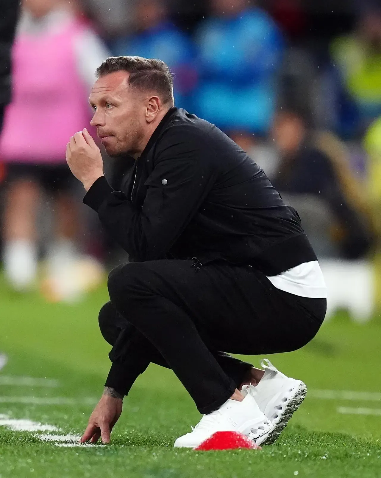 Wales manager Craig Bellamy crouches on the touchline