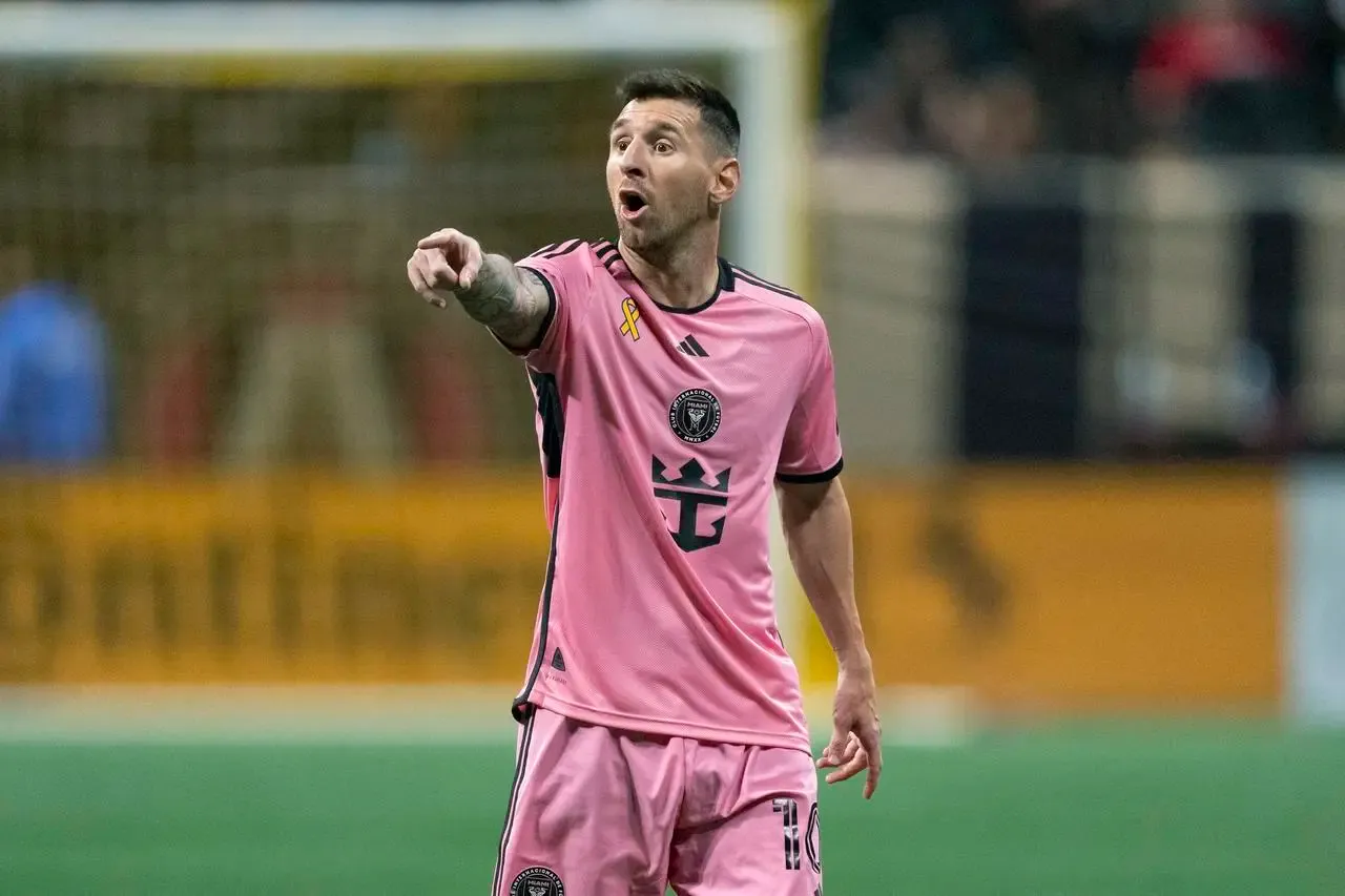 Lionel Messi points as he talks to a teammate 