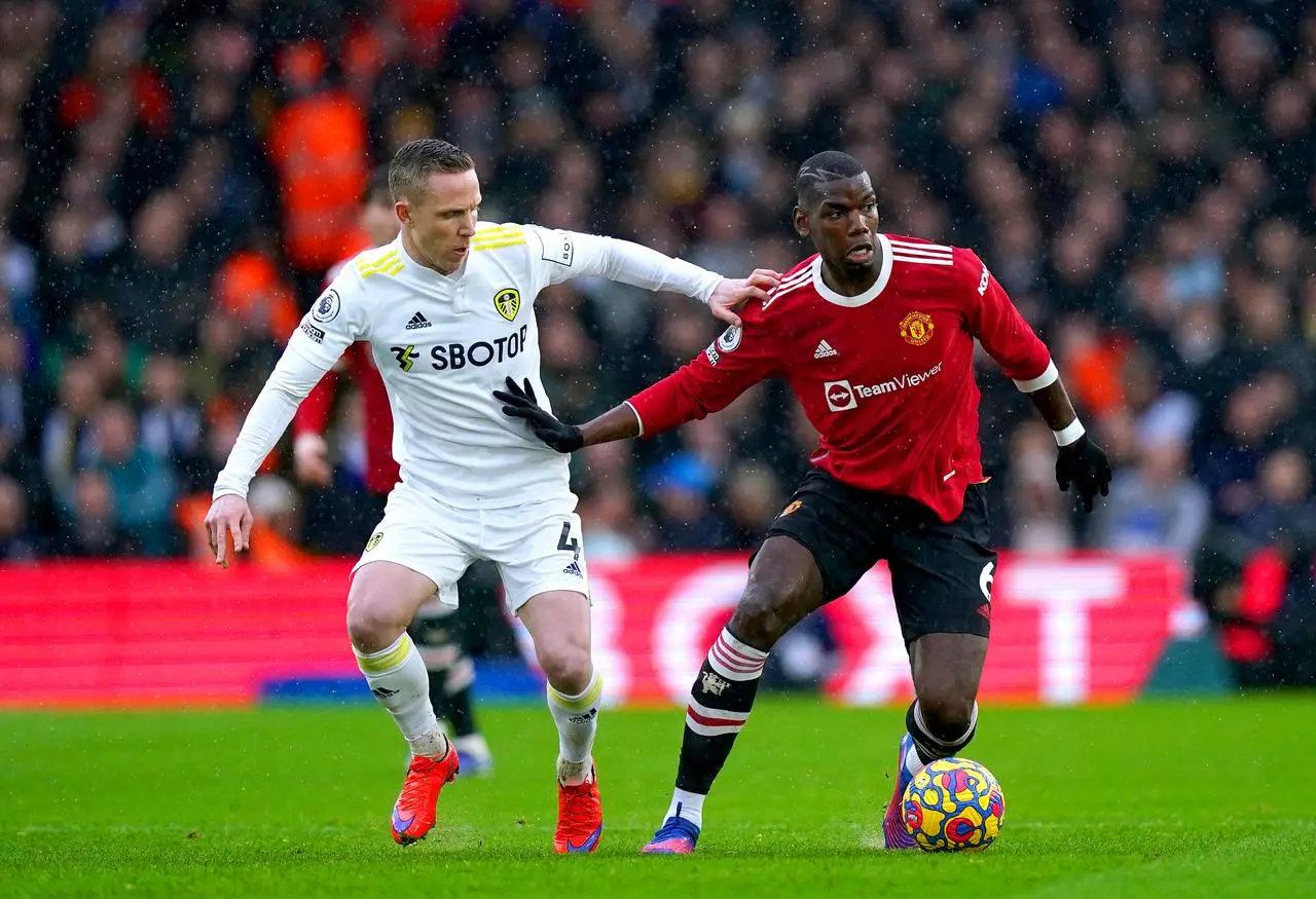 Paul Pogba (right) during his time with Manchester United, holding of Leeds' Adam Forshaw