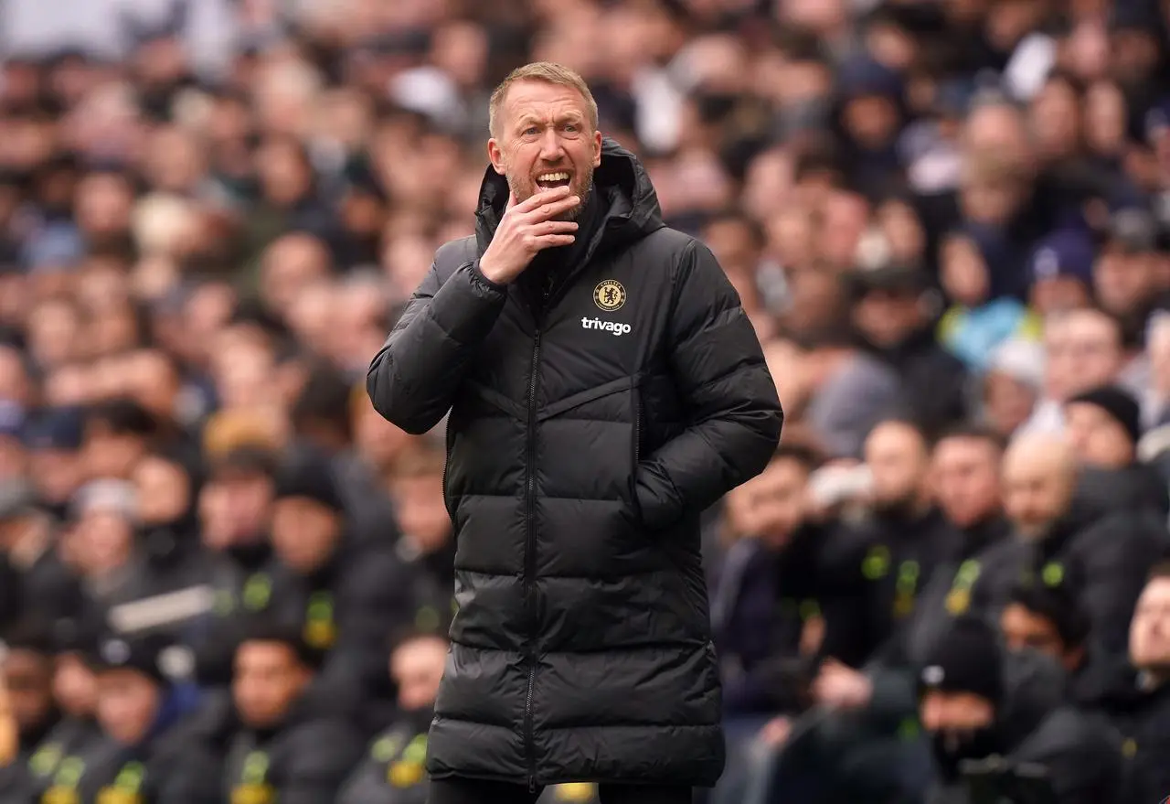 Graham Potter holds his chin in his hand on the touchline