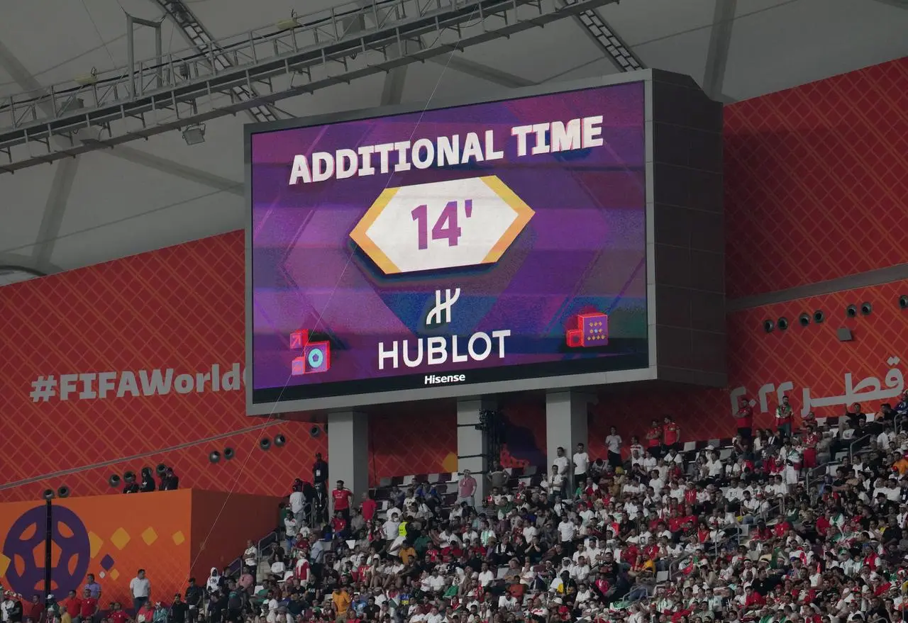 A big screen at the World Cup game between England and Iran shows 14 minutes of added time