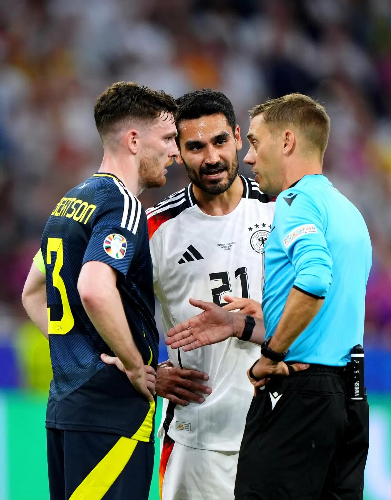 Andy Robertson and Ilkay Gundogan speak to the referee during the Euro 2024 opener between Germany and Scotland