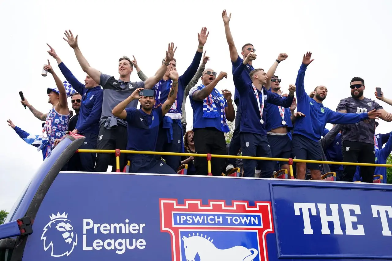 Ipswich players celebrate their promotion to the Premier League on an open-top bus parade