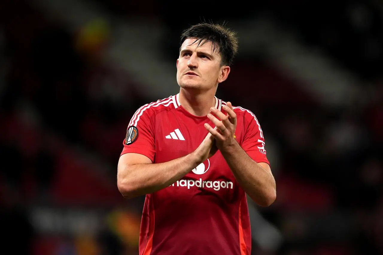 Harry Maguire applauds the fans at Old Trafford