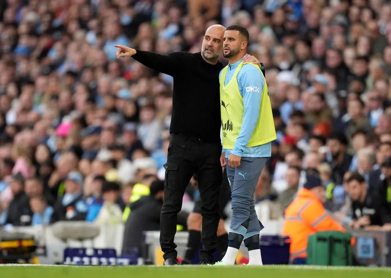 Manchester City manager Pep Guardiola speaks with substitute Kyle Walker