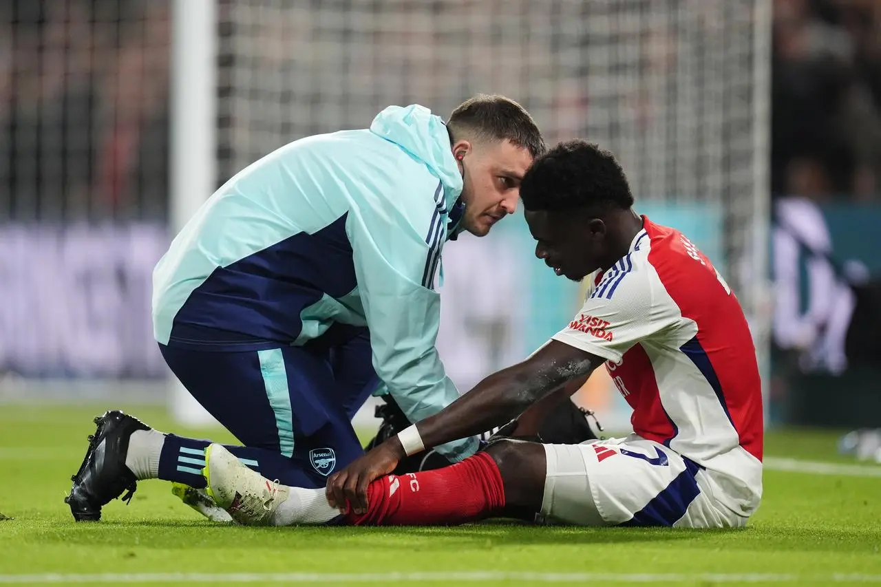 Arsenal’s Bukayo Saka recieves treatment from medical staff