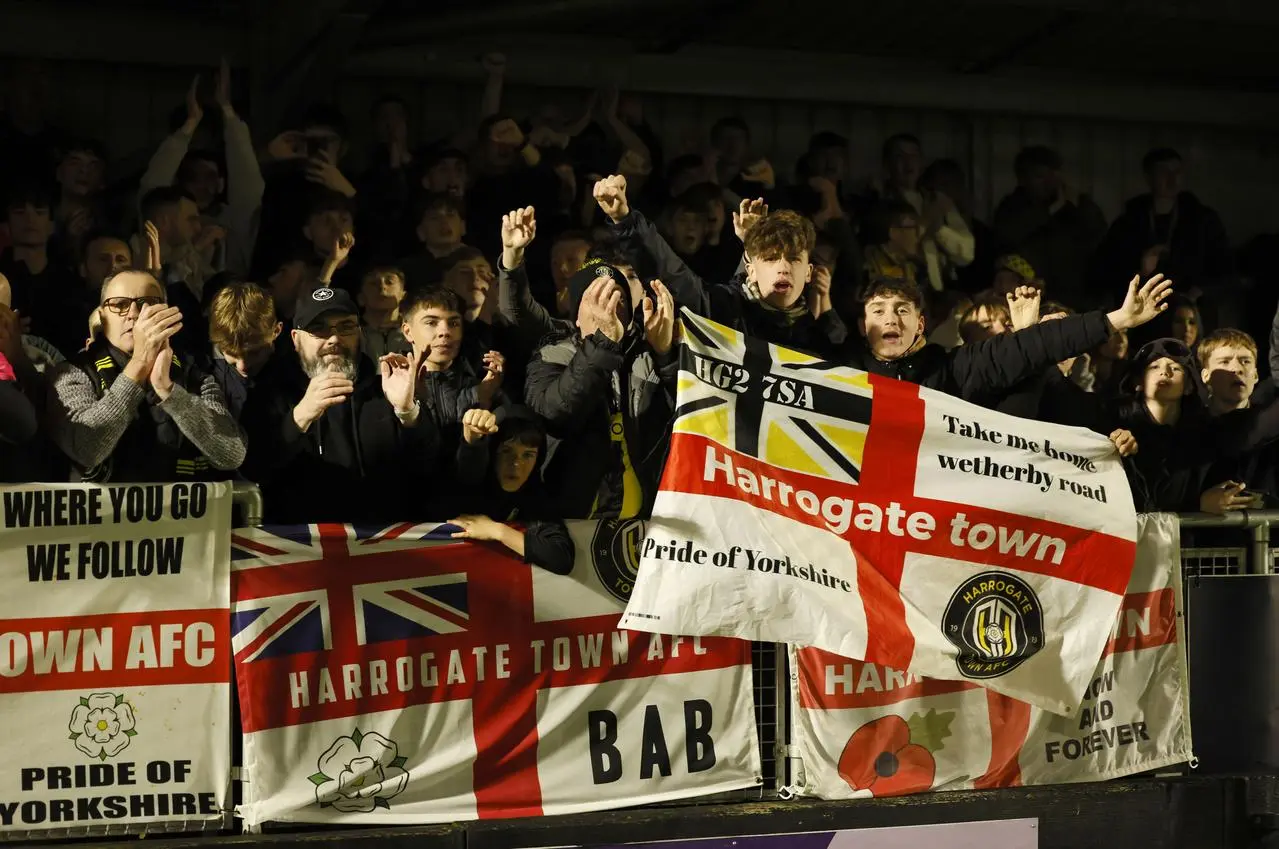 Harrogate Town fans celebrate in the stands after the Emirates FA Cup first round win against Wrexham