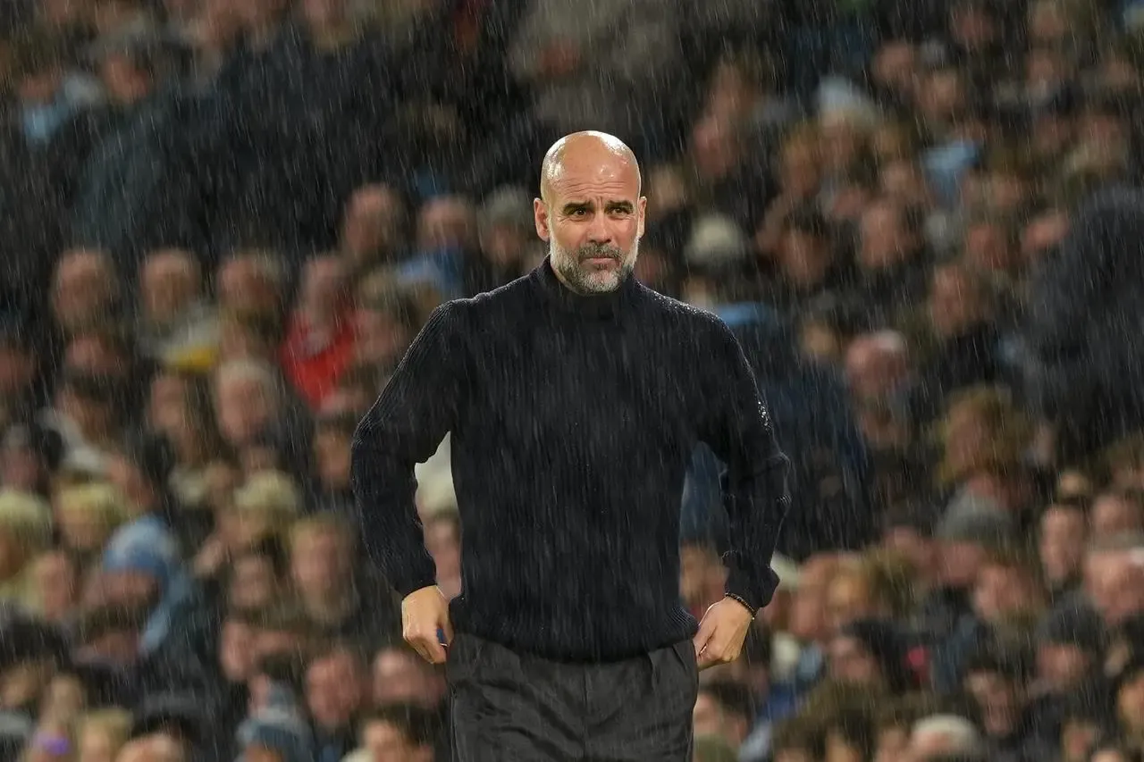 Manchester City manager Pep Guardiola stands in the rain during the loss to Tottenham