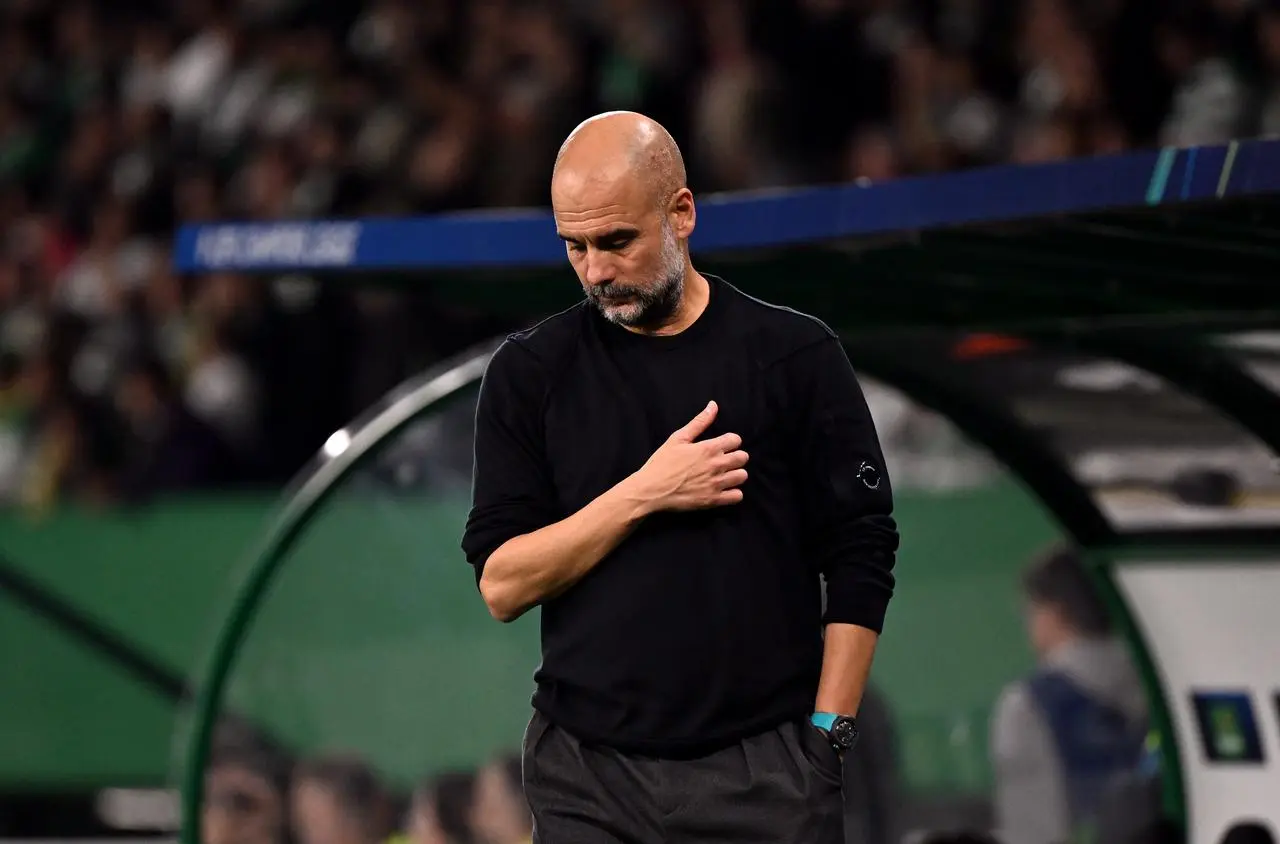 Pep Guardiola reacts with his head down during Manchester City's defeat to Sporting Lisbon