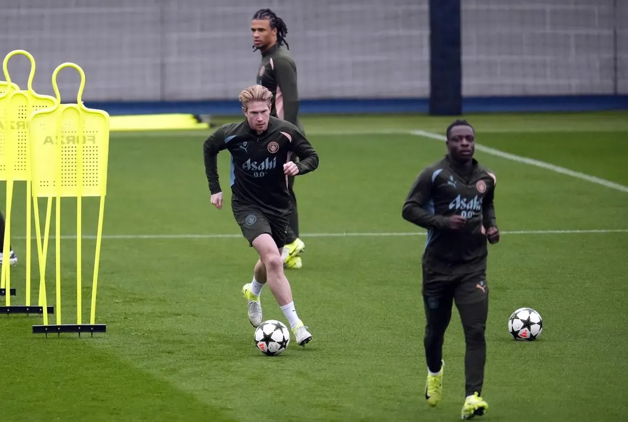 Kevin De Bruyne, centre, dribbles the ball in training with Manchester City