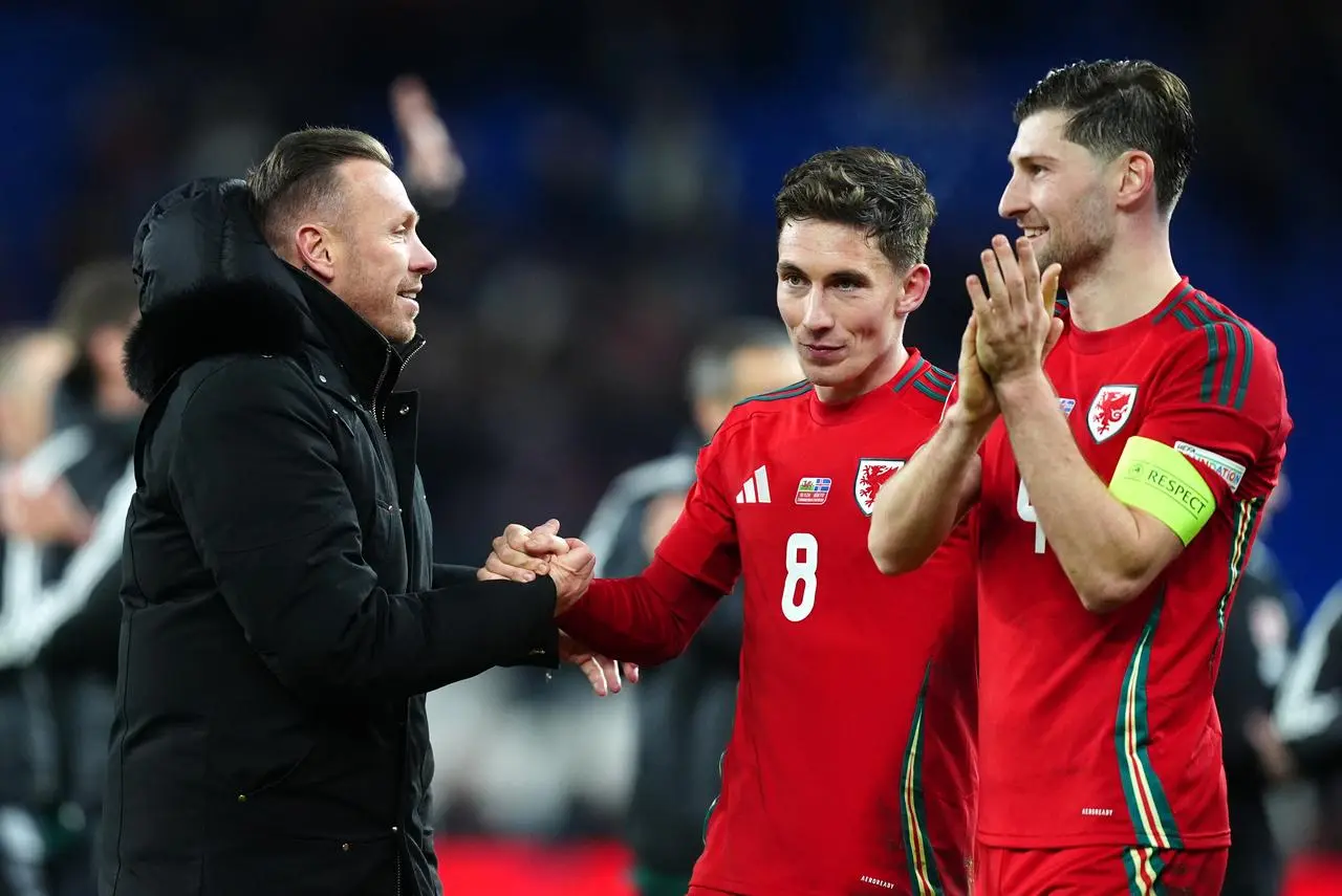 Wales manager Craig Bellamy (left) greets Harry Wilson and Ben Davies