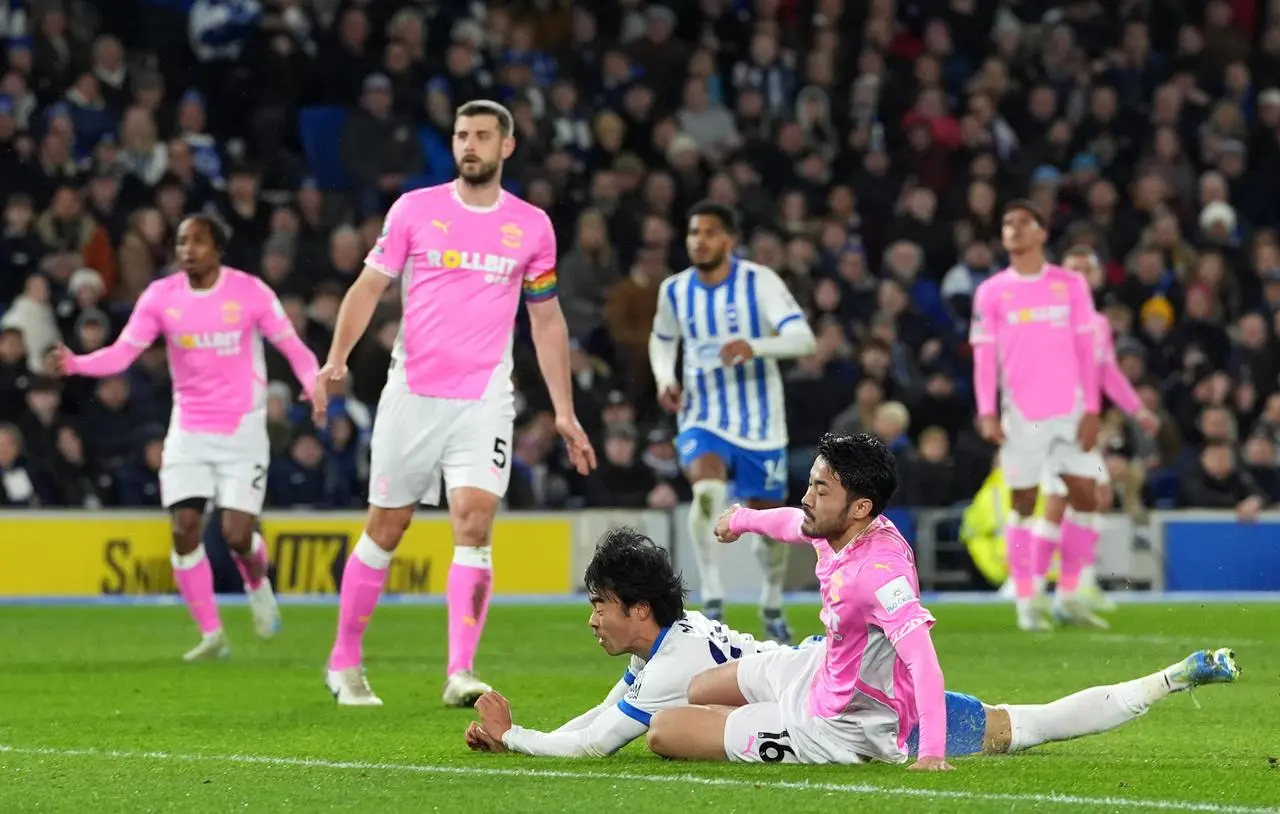 Kaoru Mitoma, centre, dives ahead of Yukinari Sugawara to head Brighton in front against Southampton