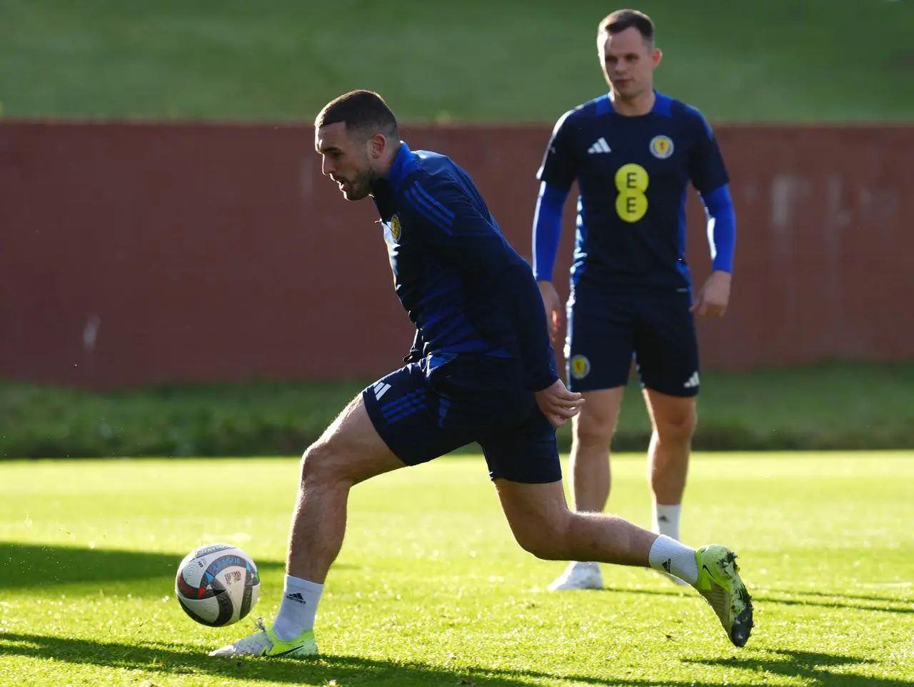 John McGinn runs with the ball at training