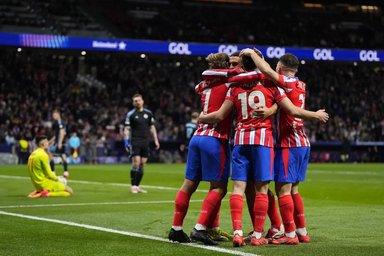 Atletico Madrid’s Antoine Griezmann, left, celebrates with teammates