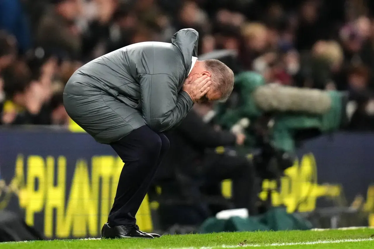 Ange Postecoglou with head in hands on touchline against Chelsea