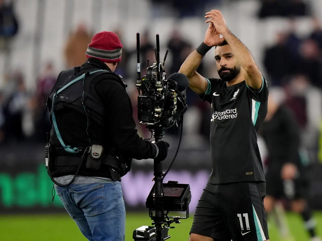 Liverpool’s Mohamed Salah applauds the fans in front of a TV camera