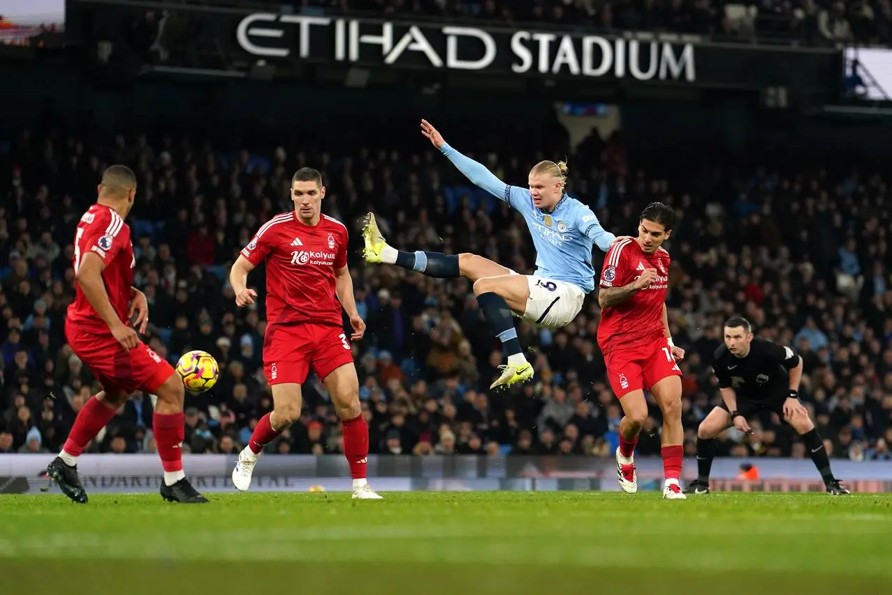 Erling Haaland, with his right arm in the air, attempts an acrobatic volley