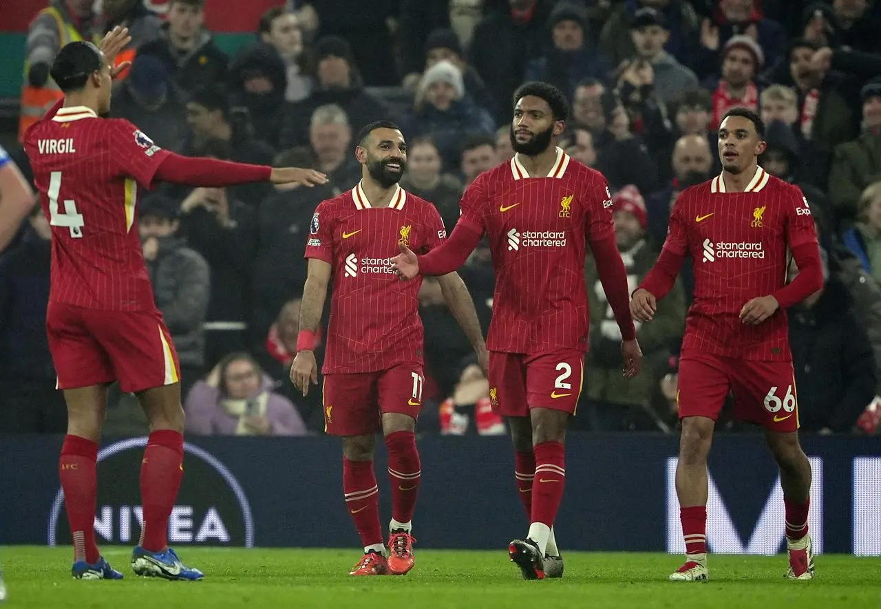 Mohamed Salah, second left, celebrates with, from left, Virgil van Dijk, Joe Gomez and Trent Alexander-Arnold after scoring Liverpool’s third goal against Leicester