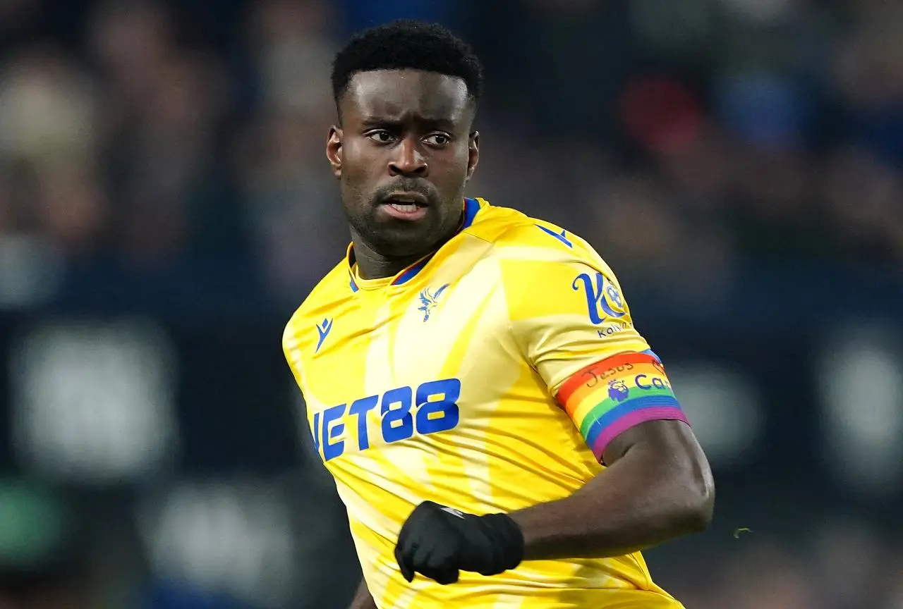 Crystal Palace’s Marc Guehi wearing a rainbow-coloured captain's arrmband displaying the words Jesus and You either side of a heart