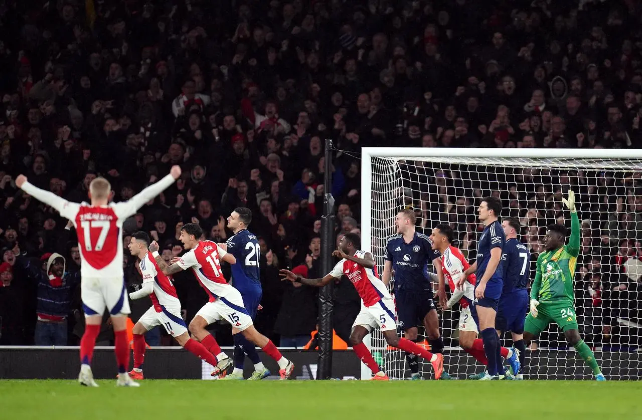 Arsenal players run to celebrate as Manchester United players look on after conceding