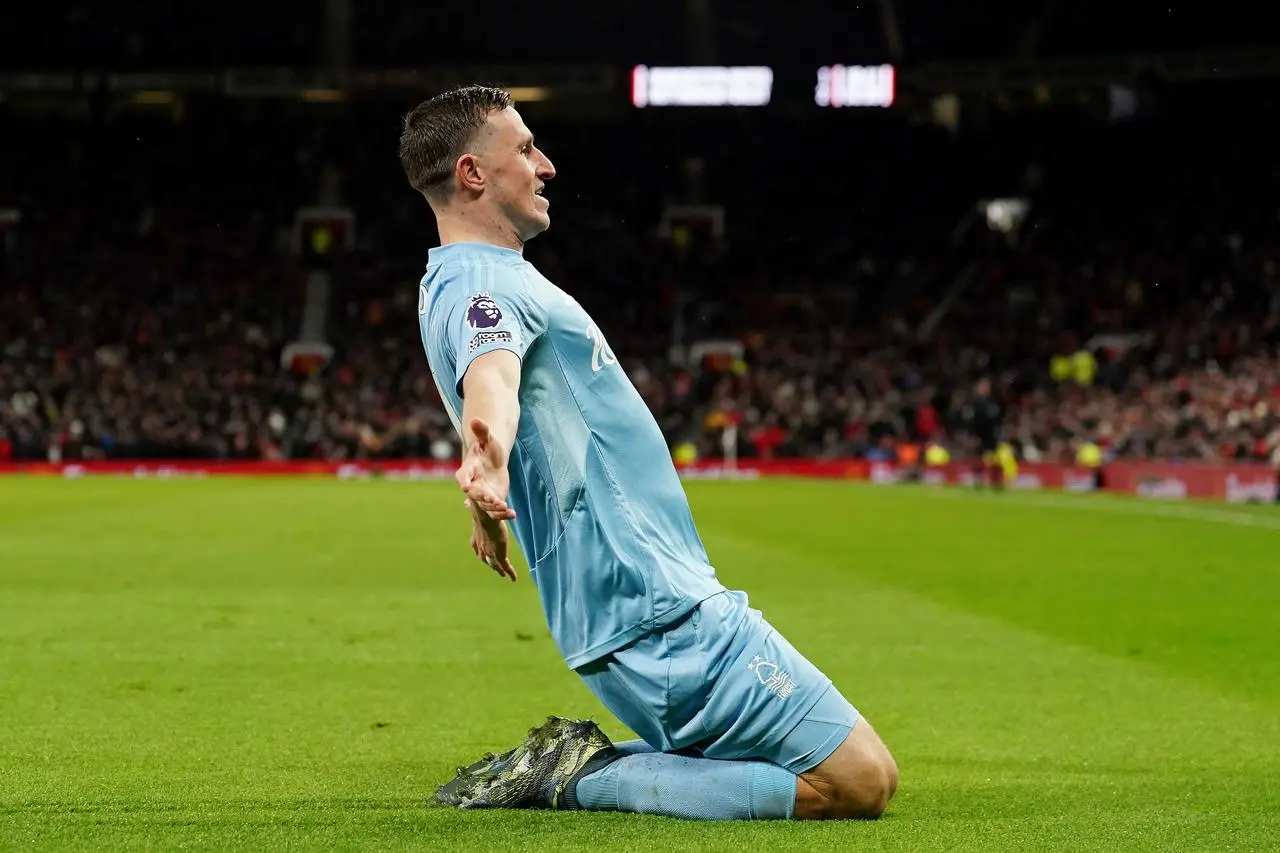 Chris Wood slides on his knees after scoring at Old Trafford