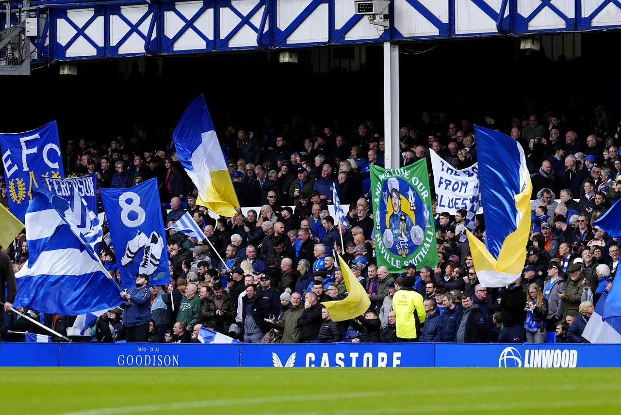 Everton fans holding flags in the stands 