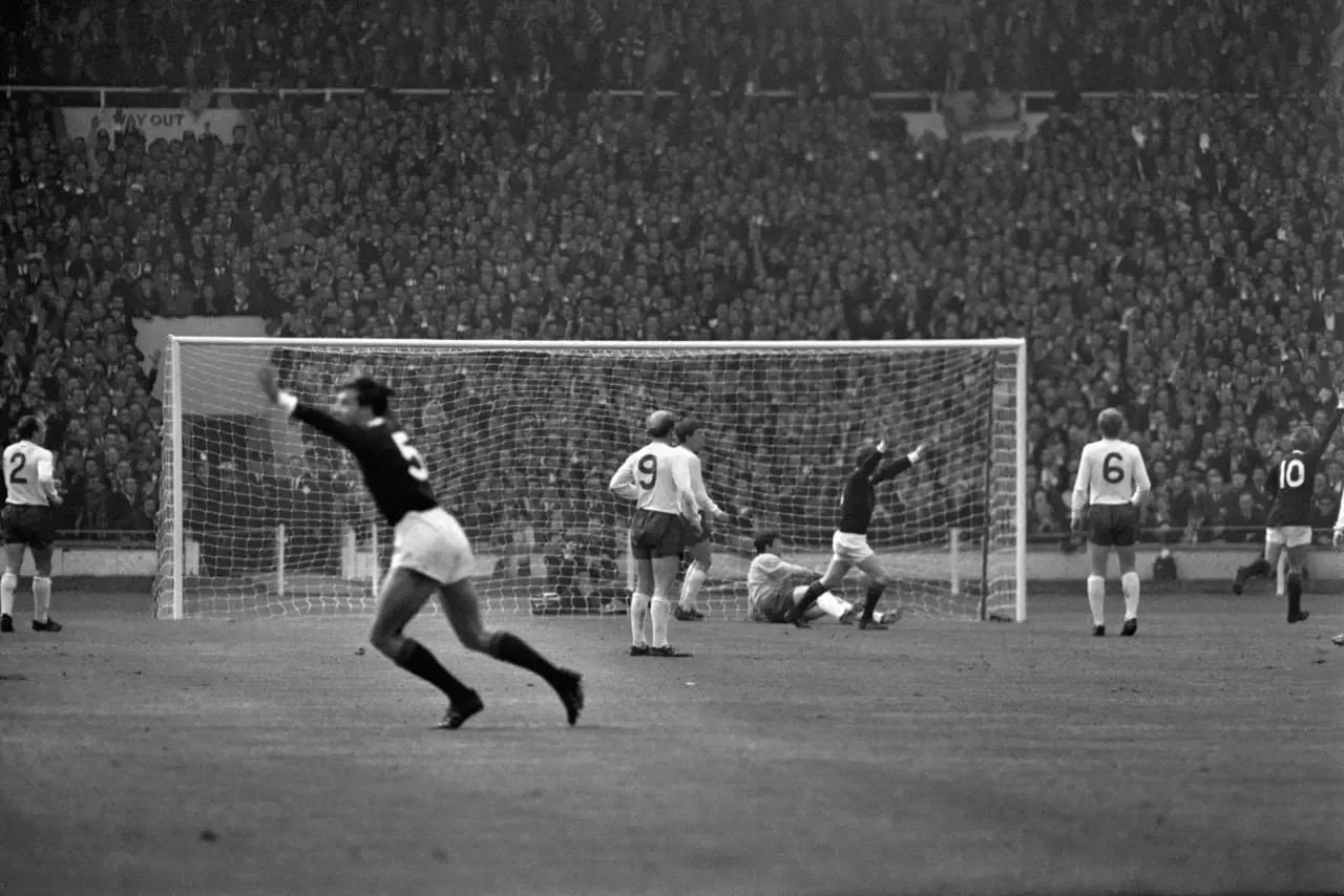 Scotland’s Denis Law lifts his arms in triumph after scoring the first goal that put his team on the road to a 3-2 win against England at Wembley Stadium