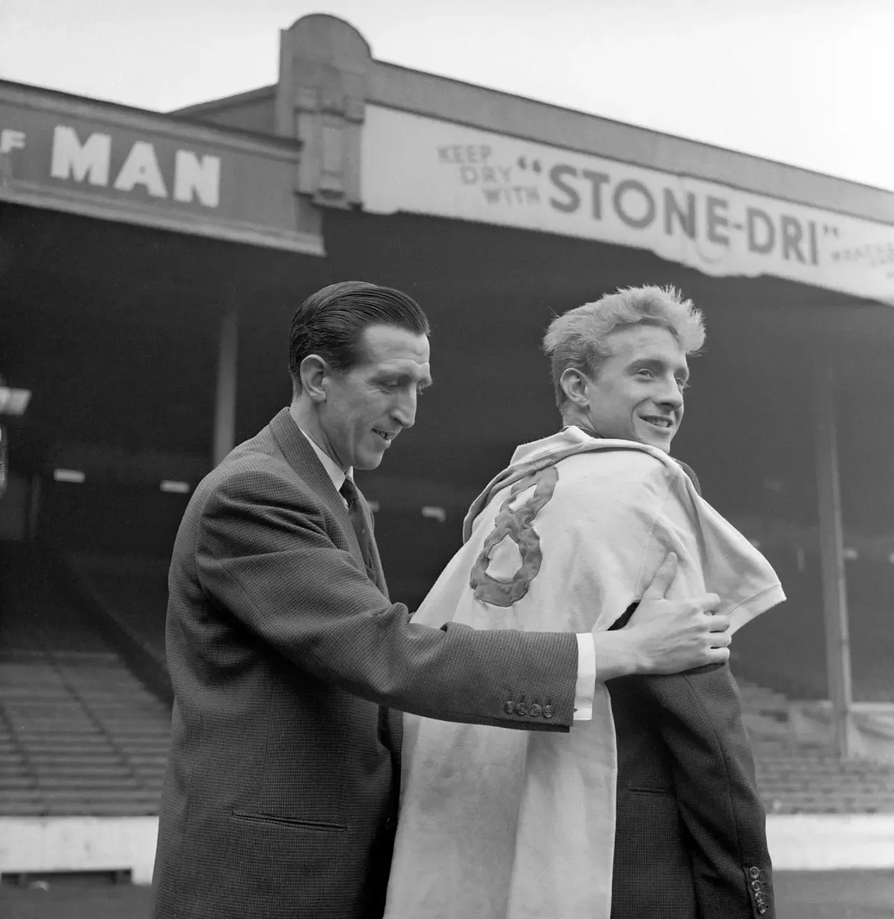 Ken Barnes (left), captain of Manchester City, trying a no. 8 jersey up against his new team-mate Denis Law