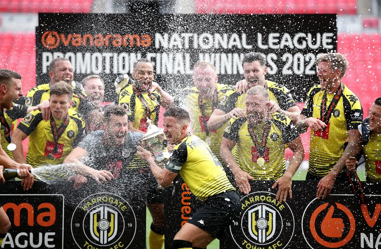 Harrogate’s Josh Falkingham lifts the trophy with team-mates after the final whistle during the Vanarama National League play-off final at Wembley 