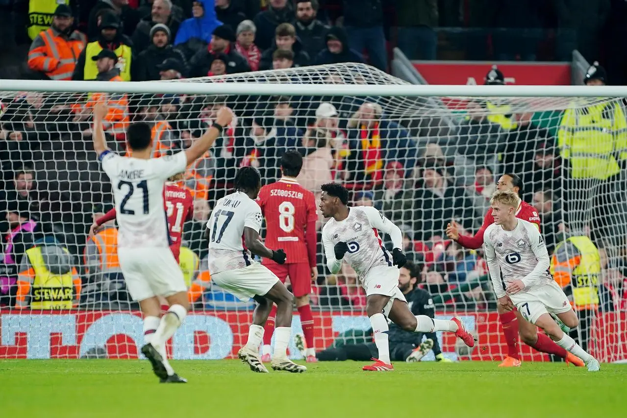 Jonathan David, centre right, wheels away to celebrates after scoring Lille’s equaliser against Liverpool