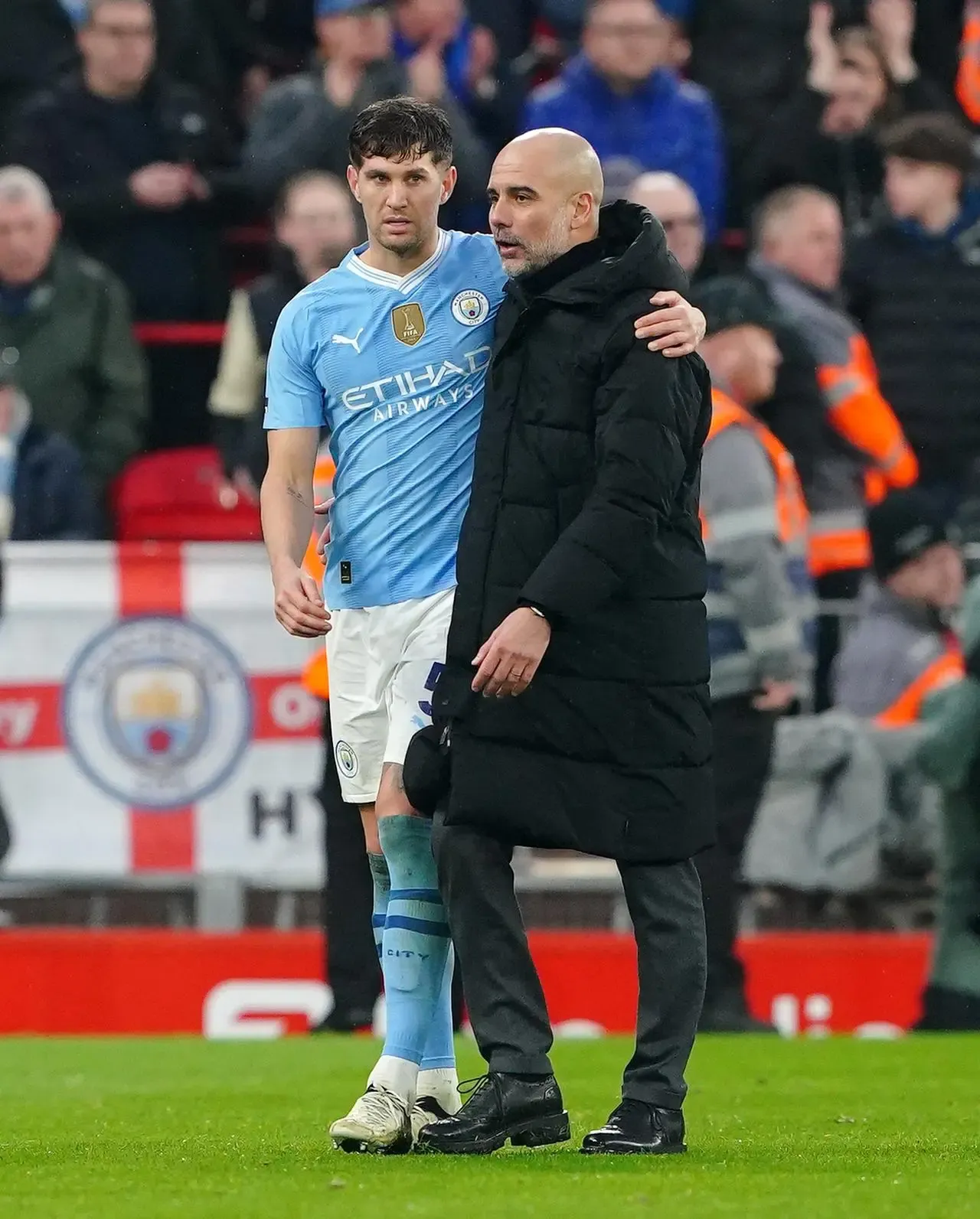 Manchester City defender John Stones and manager Pep Guardiola embrace after a game