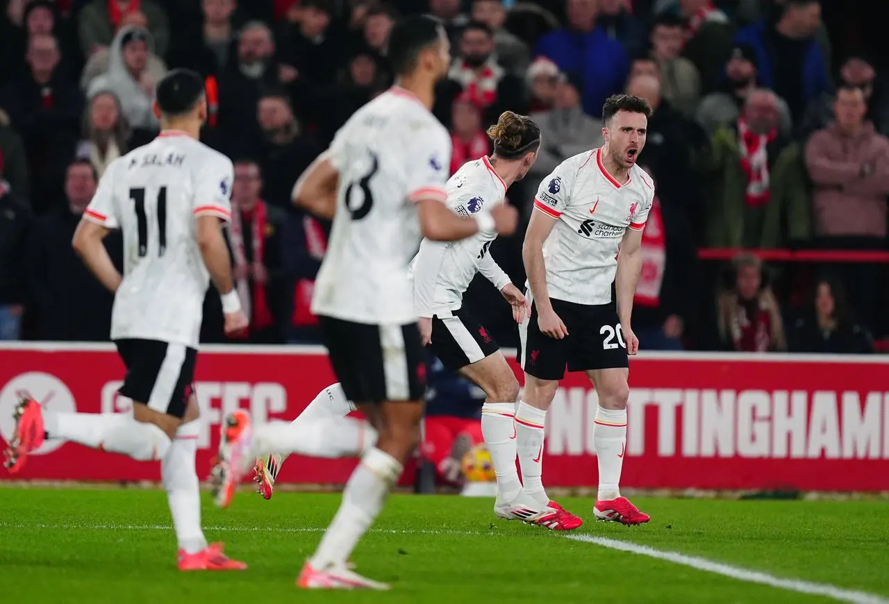 Diogo Jota, right, celebrates with fellow substitute Kostas Tsimikas, second right, after the pair combined for Liverpool's equaliser against Nottingham Forest